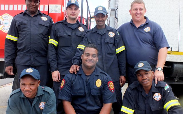 Gansbaai Brandweer se permanente beamptes, met voor vlnr M Molise (kontrakwerker), M Ackers en A Mohlabi. Agter vlnr T Xovula, J van Lill, E Bosi en G Badenhorst - Die gemeenskap is trots op julle!